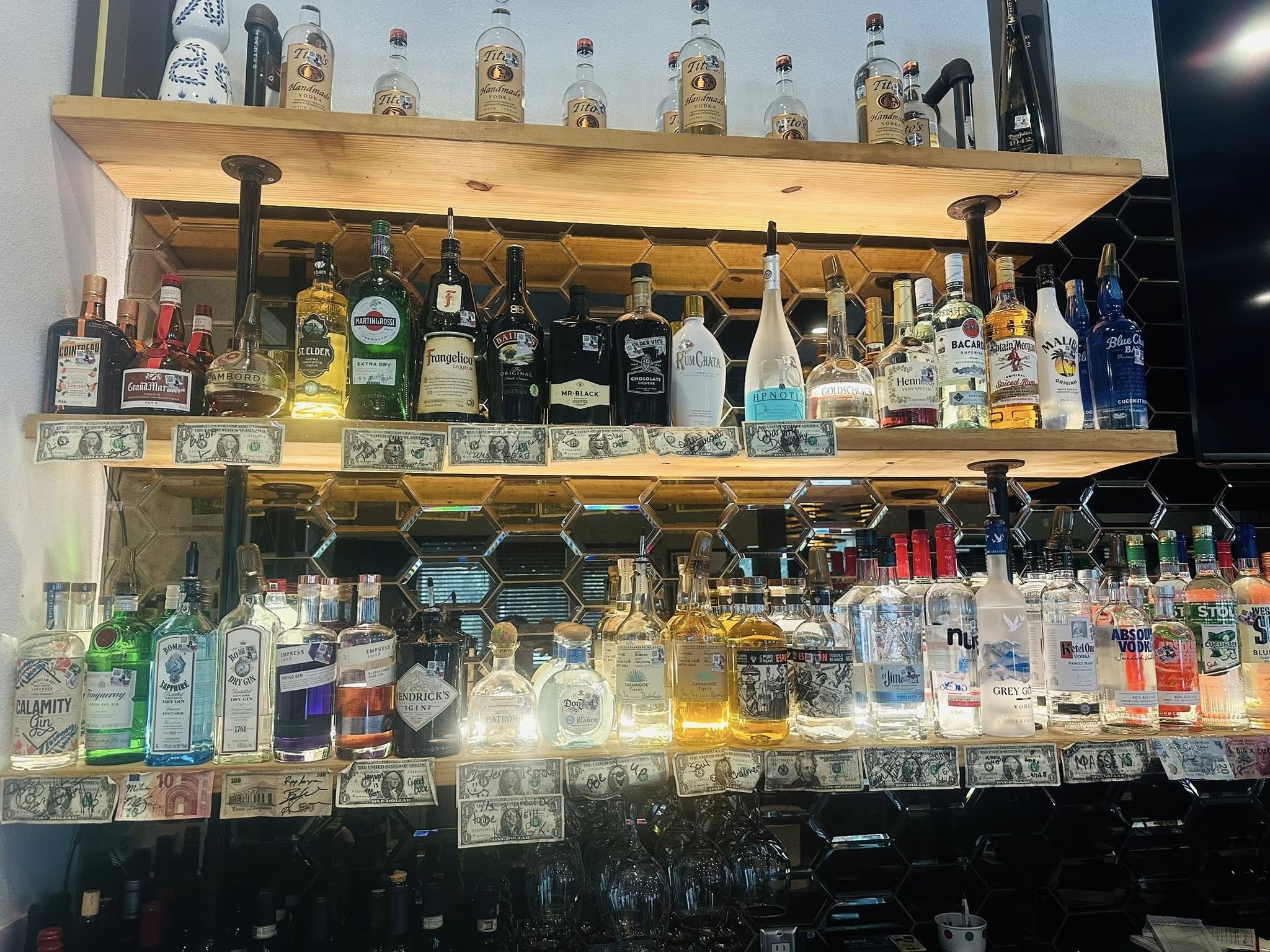 Fully stocked bar shelf with spirits