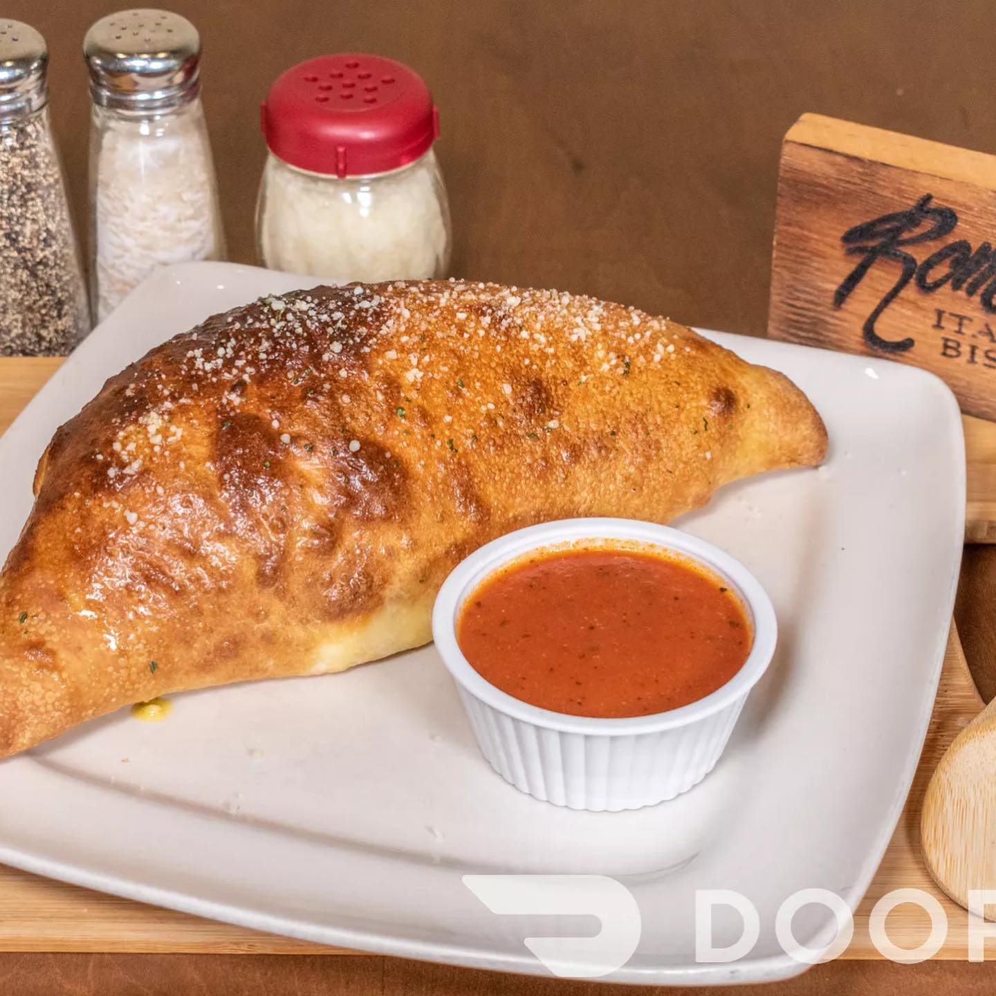 Baked calzone with a side of marinara dipping sauce