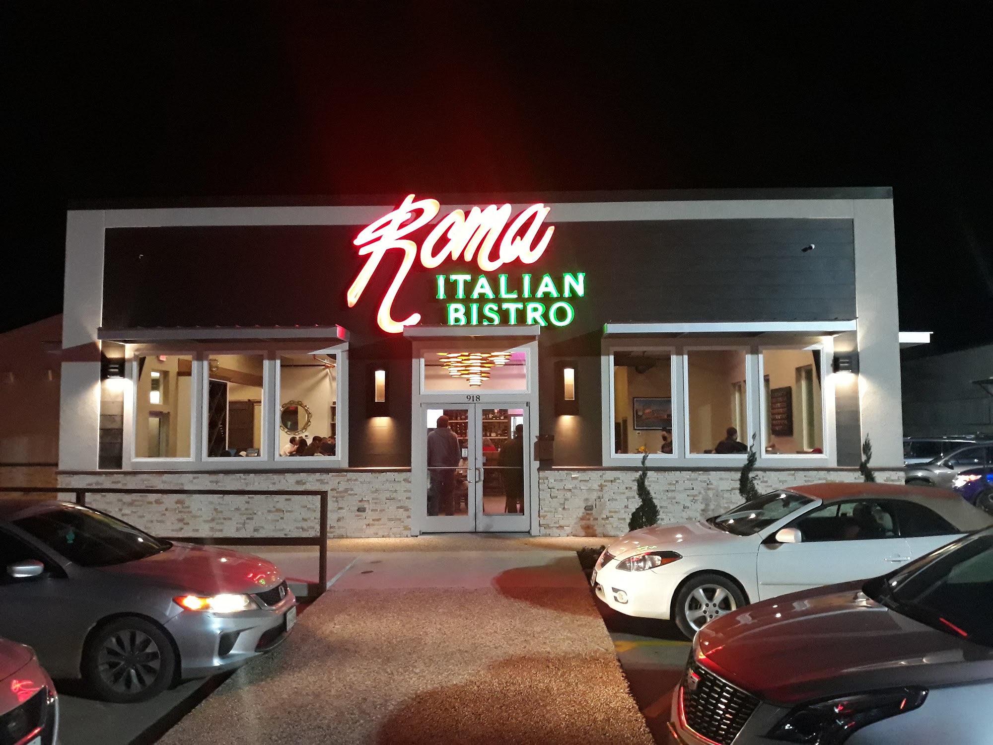 Roma Italian Bistro storefront lit up at night
